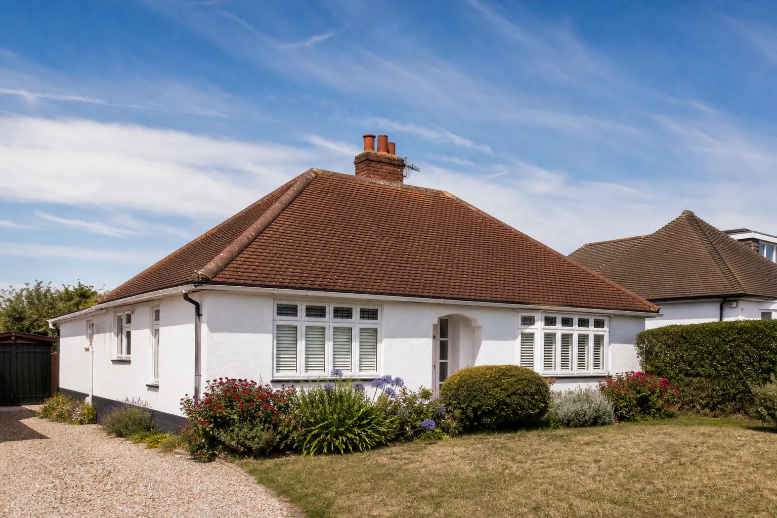 A 1930s hipped bungalow roof in clay tiles, the hips running down each corner