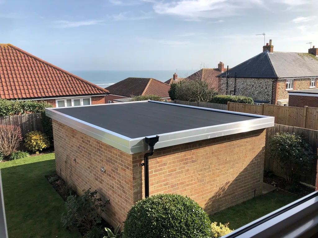 New black EPDM rubber roof with neat aluminium trims on a brick garage
