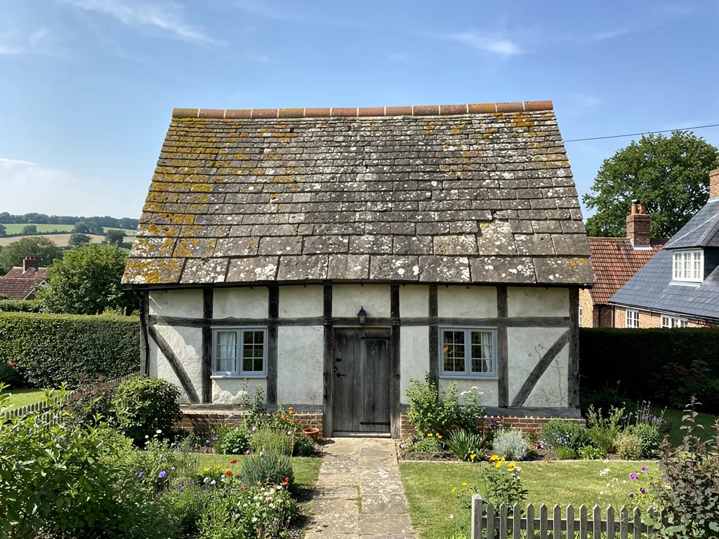 Timber-framed Wealden cottage with a heavy Horsham stone roof, the slabs getting smaller towards the ridge